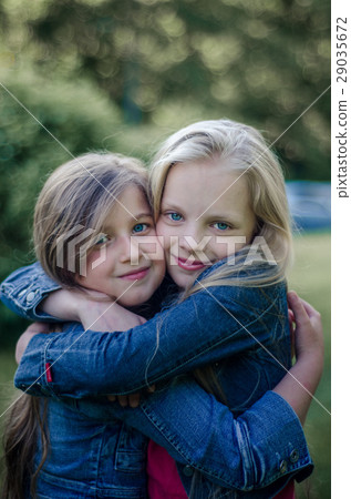 Brown and blond haired cute little girls friends. Brown and blond haired cute little girls friends. 29035672