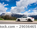 Luxury sports car against the background of the Alpine mountain range with snow in northern Italy 29036465