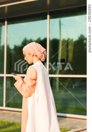 Muslim woman messaging on a mobile phone in the Muslim woman messaging on a mobile phone in the 29036893