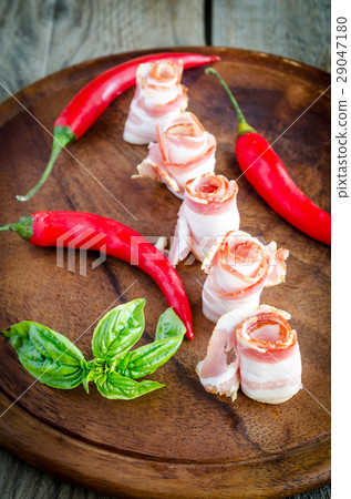 Rolled bacon strips on wooden board Rolled bacon strips on wooden board 29047180