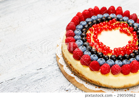 Raspberry and blueberry cheesecake on wooden table Raspberry and blueberry cheesecake on wooden table 29050962