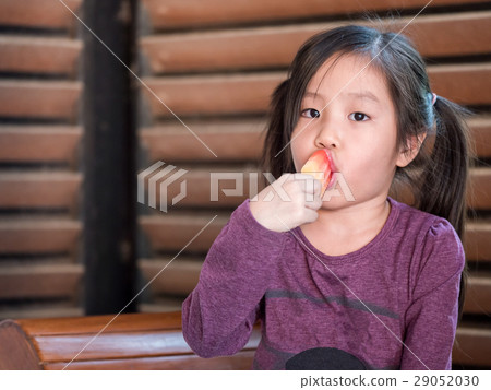Little Asian girl eating ice cream 29052030