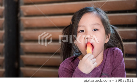 Little Asian girl eating ice cream Little Asian girl eating ice cream 29052031