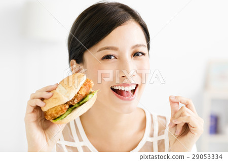 happy young woman eating big hamburger happy young woman eating big hamburger 29053334