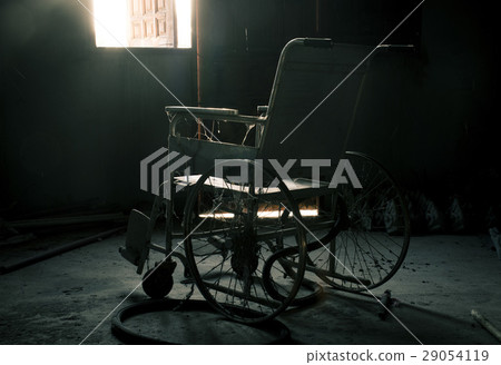 an old wheelchair in old room 29054119