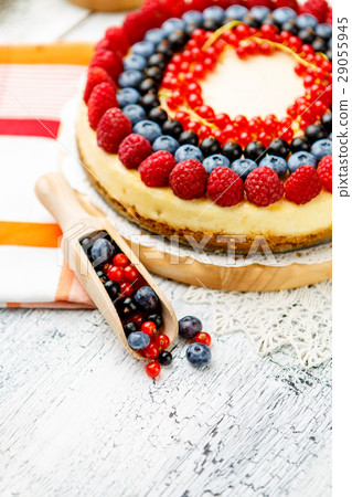 Raspberry and blueberry cheesecake on wooden table 29055945