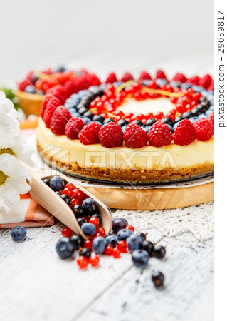 Raspberry and blueberry cheesecake on wooden table Raspberry and blueberry cheesecake on wooden table 29059817