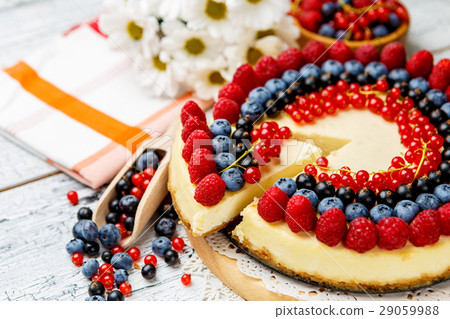 Raspberry and blueberry cheesecake on wooden table Raspberry and blueberry cheesecake on wooden table 29059988