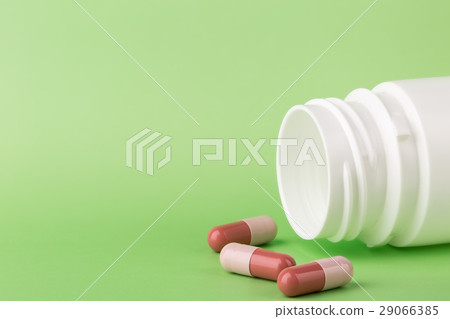 Brown pills and a bottle of medicine Brown pills and a bottle of medicine 29066385