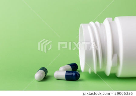 Blue pills and a bottle of medicine Blue pills and a bottle of medicine 29066386