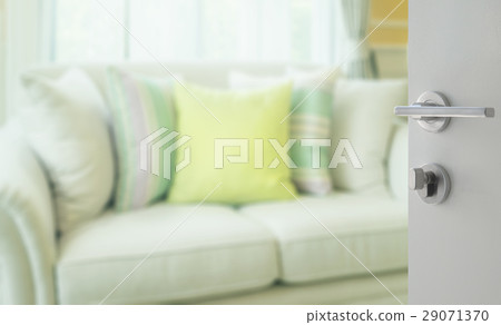 opened white door to living room with green pillow opened white door to living room with green pillow 29071370