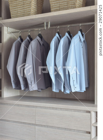 Light blue and grey shirts in wooden wardrobe 29071425