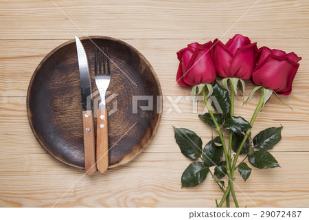 romantic setting with a wood dish and red roses 29072487