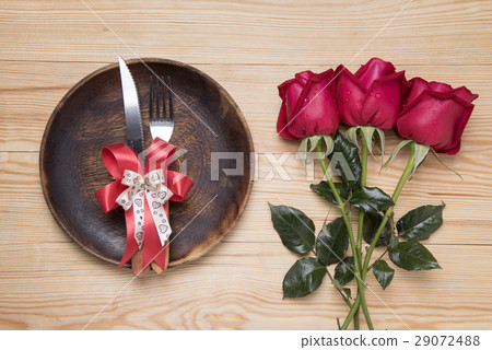 romantic setting with a wood dish and red roses 29072488