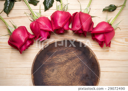romantic setting with a wood dish and red roses 29072490