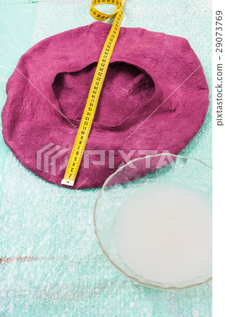 wet felt beret is forming on table 29073769
