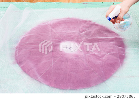 hatter wets the fibers on back side of hat layout 29073863