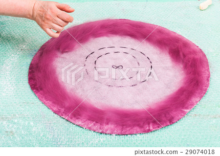 milliner spreads fibers on back side of hat layout 29074018