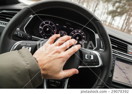 Driver hand pushes a steering wheel klaxon 29078392