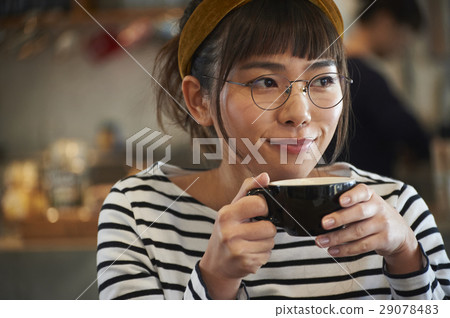 A woman relaxing at a cafe 29078483