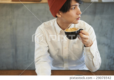 A man relaxing at a cafe 29078542