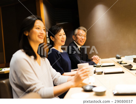 Men and women enjoying sushi 29080037