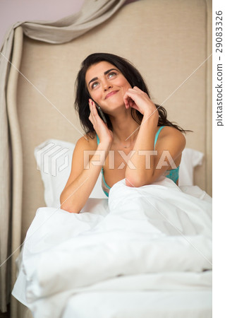 Lady in bed with phone. Lady in bed with phone. 29083326