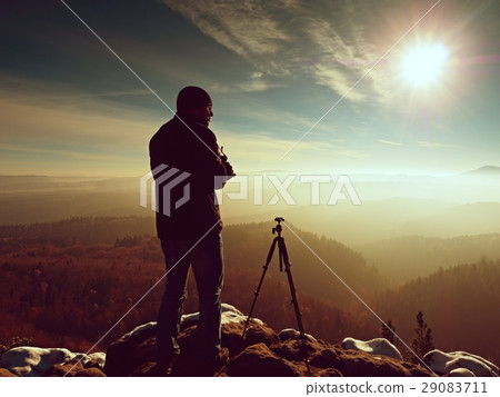 Photographer stay with camera ind hands  at tripod 29083711