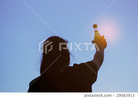 girl holds a bottle of water at sky. girl holds a bottle of water at sky. 29083913