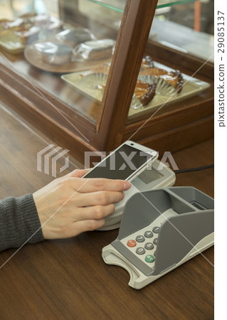 Woman hand holding smartphone to pay cashless closing Woman hand holding smartphone to pay cashless closing 29085137