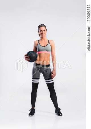 Fitness woman in sports clothing holding medicine Fitness woman in sports clothing holding medicine 29089211