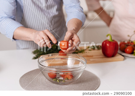Capable son helping his aged mother cooking in the 29090100