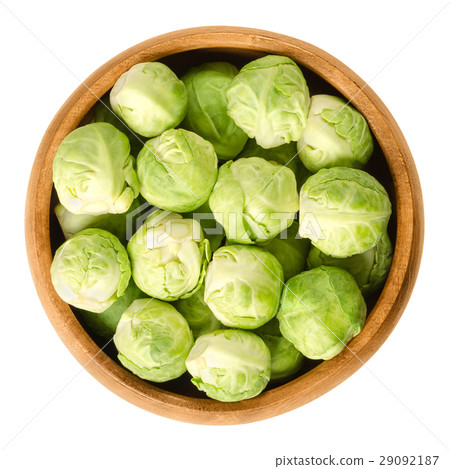 Brussels sprouts in wooden bowl over white 29092187