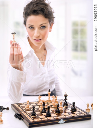 Pretty young businesswoman playing chess Pretty young businesswoman playing chess 29093913