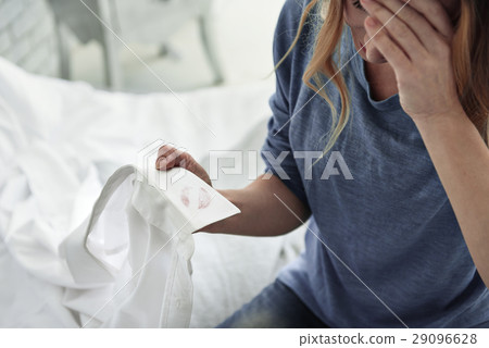 Despaired woman holding jacket of husband 29096628