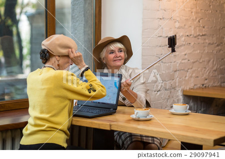 Senior woman holding selfie stick. 29097941