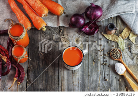 Carrot juice in glass jars and iron mug Carrot juice in glass jars and iron mug 29099139