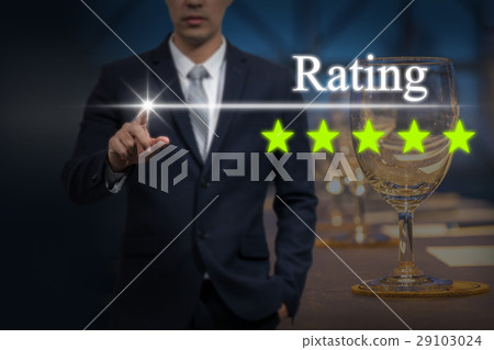 Businessman pointing five star button to increase rating of hotel over workplace with Glass of water, paper and pencil on the table in the hall room, business evaluation concept, Increase rating 29103024