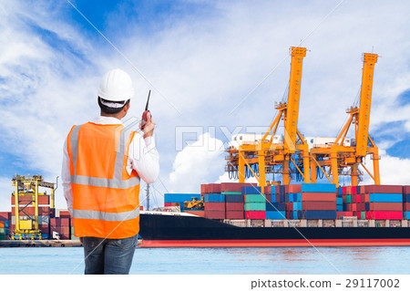 Dock worker talking on radio at ship port 29117002