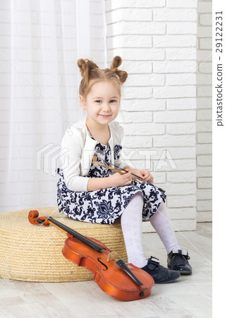 little girl sits, holds a bow and smile language 29122231