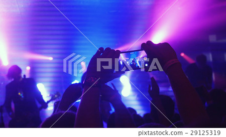 Fans waving their hands recording video and taking 29125319