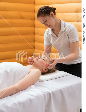 Young pretty woman enjoying face massage procedure 29128522