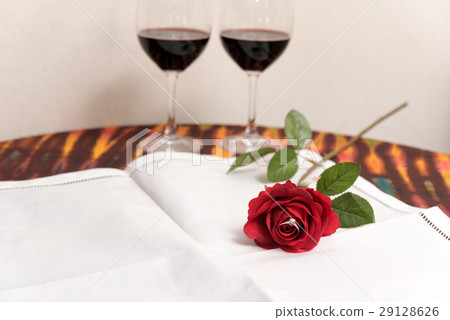 Diamond ring inside red rose over two wine glasses Diamond ring inside red rose over two wine glasses 29128626