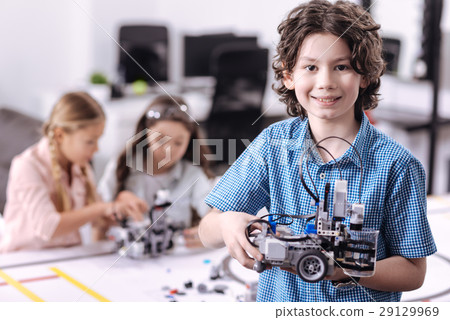 Delighted boy holding robot at school 29129969