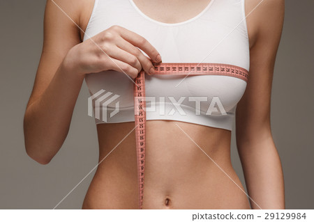The girl taking measurements of her body, white The girl taking measurements of her body, white 29129984