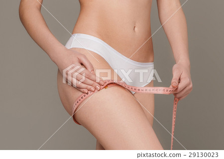 The girl taking measurements of her body, white The girl taking measurements of her body, white 29130023