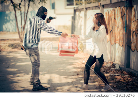 Thief stealing woman and threatening with gun 29130276