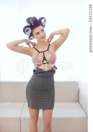 Woman in hair curlers dressing indoors 29131199