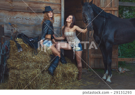 Women flirt on farm, the horse stands nearby. Women flirt on farm, the horse stands nearby. 29131293