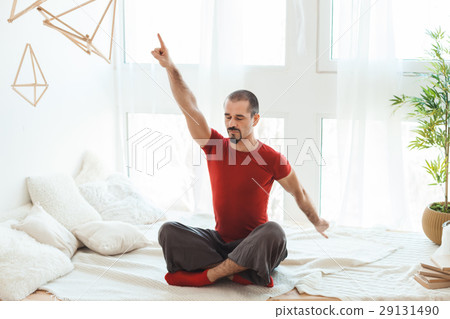 Man in a yoga pose does gymnastics. 29131490
